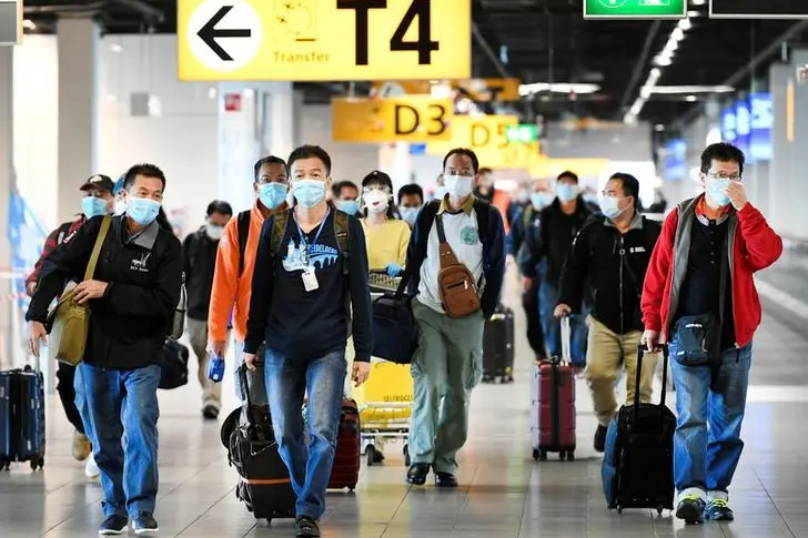 People wearing protective face masks walk, as Schiphol Airport reduces its flights due to the coronavirus disease (COVID-19) outbreak, in Amsterdam, Netherlands April 2, 2020.  , Reuters Images/Piroschka van de Wouw