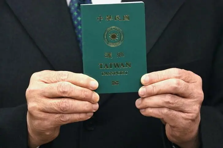 Taiwan Foreign Minister Joseph Wu takes photos with a sample of the new Taiwan passport in Taipei, Taiwan, January 11, 2021.  , Reuters Images/Ann Wang