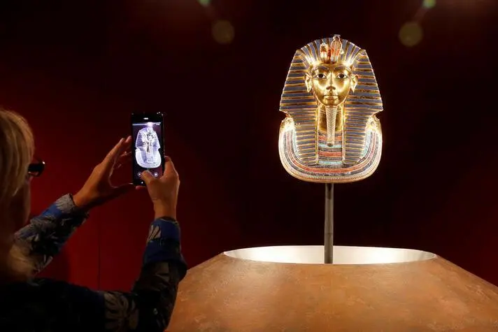 A woman takes a picture of a true-to-scale replica mask of ancient Egypt king Tutankhamun during a media preview of the exhibition \"Tutankhamun: His Tomb and Treasures\", as the coronavirus disease (COVID-19) outbreak continues, in Zurich, Switzerland July 9, 2020. , Reuters Images/Arnd Wiegmann