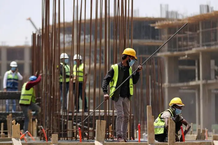Image used for illustrative purpose. Workers wearing protective face masks stand on a building under construction in the New Administrative Capital (NAC), east of Cairo, amid concerns about the spread of the coronavirus disease (COVID-19), in Egypt May 6, 2020. , Reuters/Mohamed Abd El Ghany