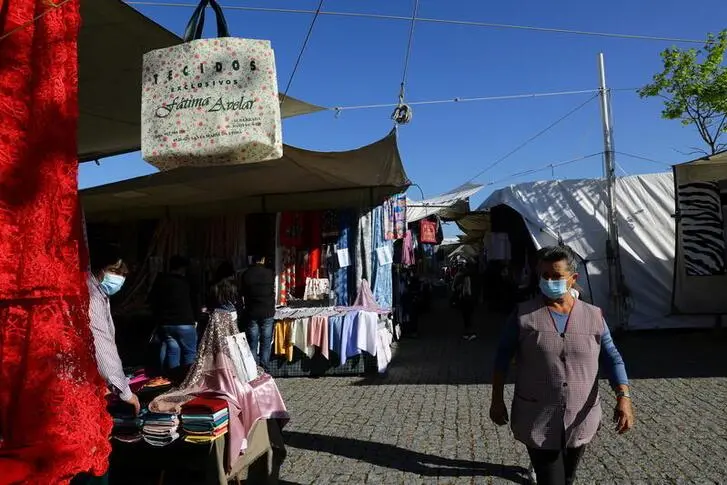 People go shopping at a weekly municipal non-food market as the country eases the coronavirus disease (COVID-19) restrictions, in Espinho, Portugal, April 5, 2021. , Reuters Images/Violeta Santos Moura