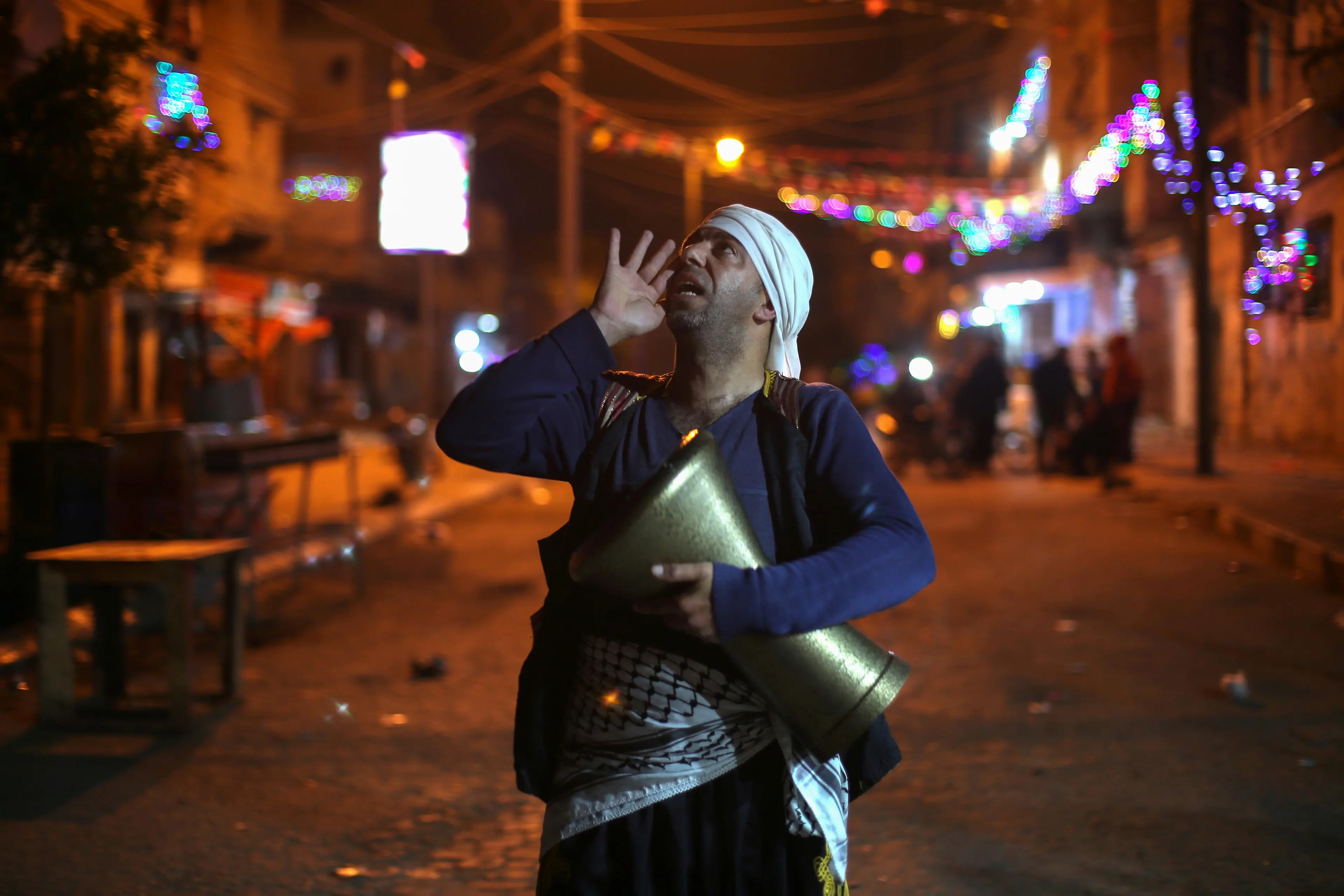 A Palestinian Mesaharati holds a drum as he calls out to wake up Muslims to have the predawn meal before they start their long-day fast, during the holy month of Ramadan, amid the coronavirus disease (COVID-19) outbreak, in Khan Younis in the southern Gaza Strip April 15, 2021. REUTERS , Ibraheem Abu Mustafa