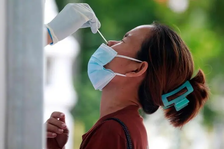 A woman gets a free coronavirus disease (COVID-19) test after queueing overnight at a temple in Bangkok, Thailand, July 10, 2021. , Reuters Images/Soe Zeya Tun