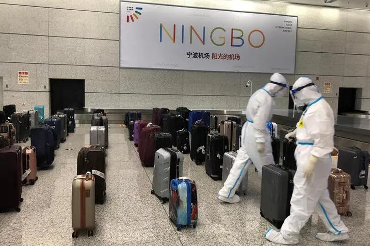 Workers in protective suits sort luggage arriving from India at Ningbo Lishe International Airport following the global coronavirus disease (COVID-19) outbreak, in Ningbo, Zhejiang province, China, September 10, 2020.  , Reuters Images/Shivani Singh