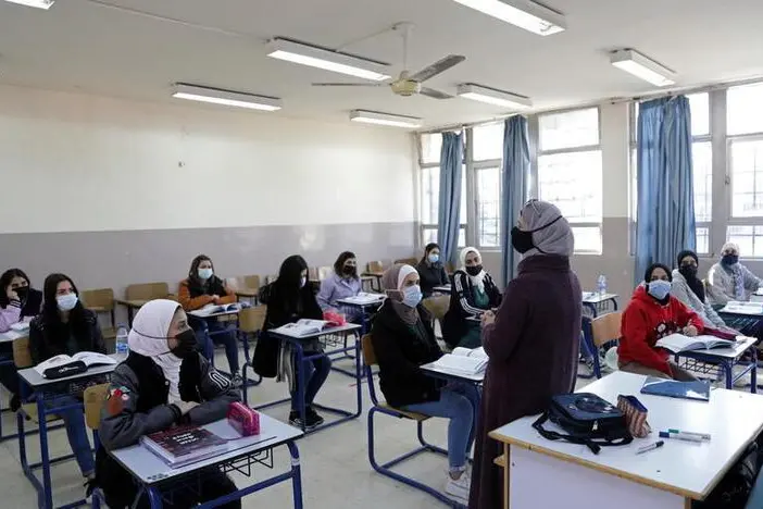 Students wearing protective face masks attend a class following the reopening of their school, after the government eased the coronavirus disease (COVID-19) restrictions in Amman, Jordan February 7, 2021. , Reuters Images/Alaa Al Sukhni 