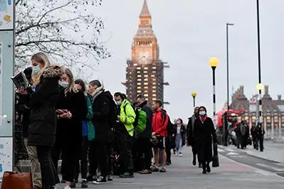People queue at Westminster Bridge to receive COVID-19 vaccine and booster doses, as the spread of the coronavirus disease (COVID-19) continues, at a walk-in vaccination centre at Saint Thomas\\' Hospital in London, Britain, December 14, 2021.  , Reuters Images/Toby Melville